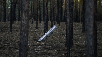 A Russian rocket sticks out of the ground in a forest near Oleksandrivka village, Ukraine.