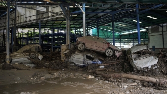 Cars are piled up in a workshop after intense rains caused flash flooding in Venezuela