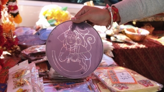 a stencil for rangoli — colored powder designs — on sale at a Diwali stall in New York