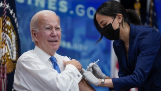 President Joe Biden receives his COVID-19 booster from a member of the White House medical unit