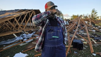 Fred Davis wipes his face as he describes building his home and the damage after a tornado hit in Powderly, Texas.