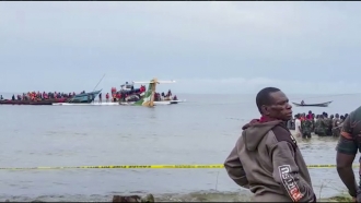 Rescuers in boats are seen around the tail fin of a crashed Precision Air passenger aircraft on the shores of Lake Victoria.