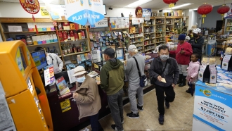 People stand in line to buy Powerball lottery tickets.