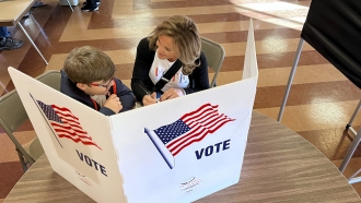 Julie Abbott, right, Republican candidate for New York State Senate, fills out her ballot with her son, Carson Kenan