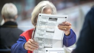 An election worker inspects a mail-in ballot in the count room in Las Vegas, Nevada.