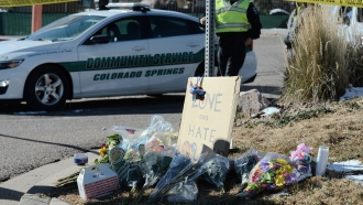 Flowers and a sign reading "love over hate" lay near a gay nightclub in Colorado Springs, Colo., Sunday, Nov. 20, 2022.
