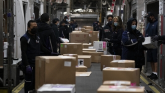 Employees sort packages for delivery at FedEx