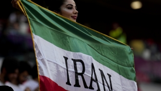A soccer fan holds a flag from Iran prior to the World Cup