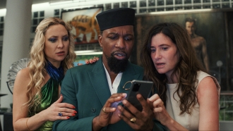 Kate Hudson, Leslie Odom Jr. and Kathryn Hahn are shown in a scene from "Glass Onion: A Knives Out Mystery."