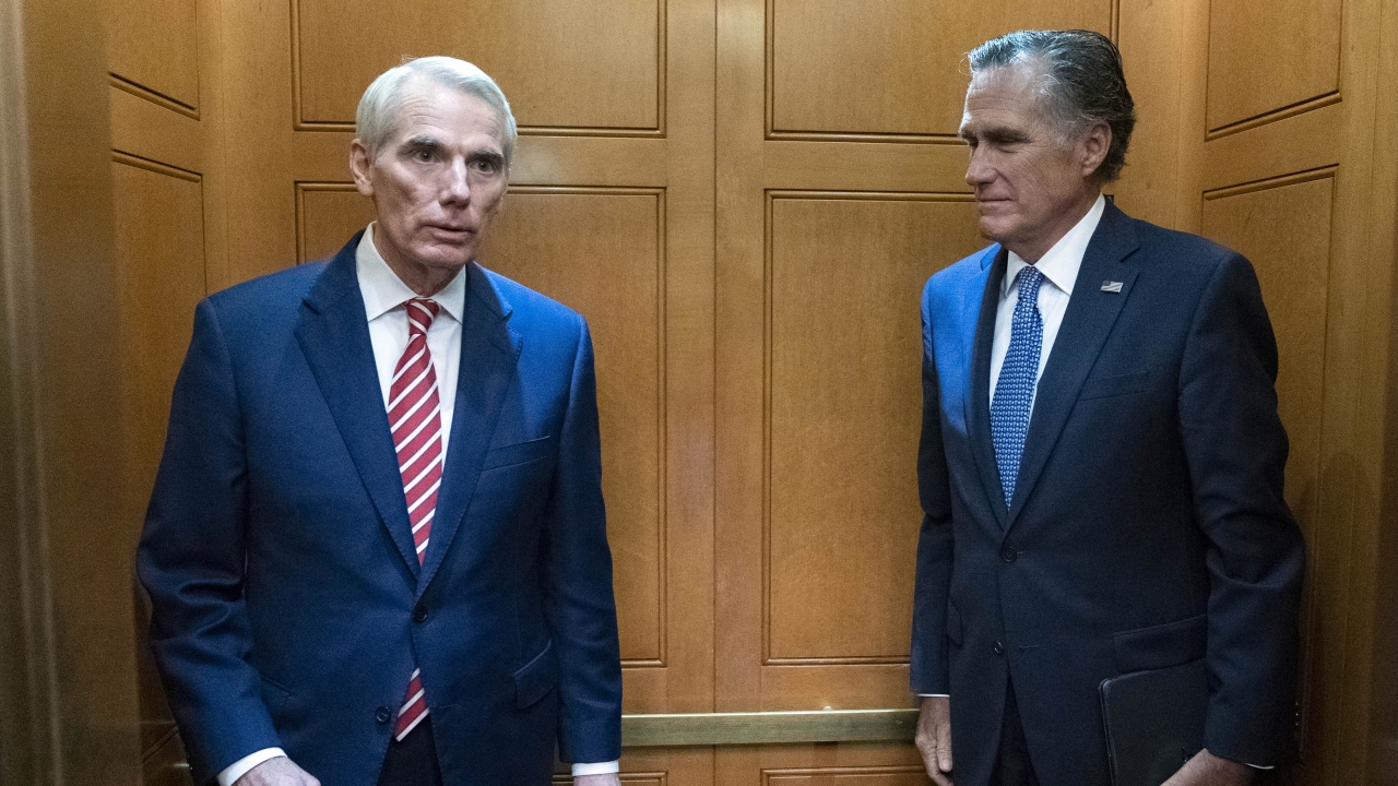 Sen. Rob Portman, R-Ohio, left, accompanied by Sen. Mitt Romney, R-Utah, leave in the elevator after a closed door talks.