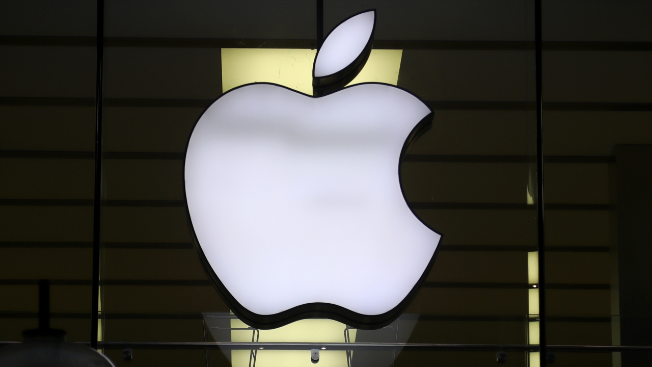 The logo of Apple is illuminated at a store.
