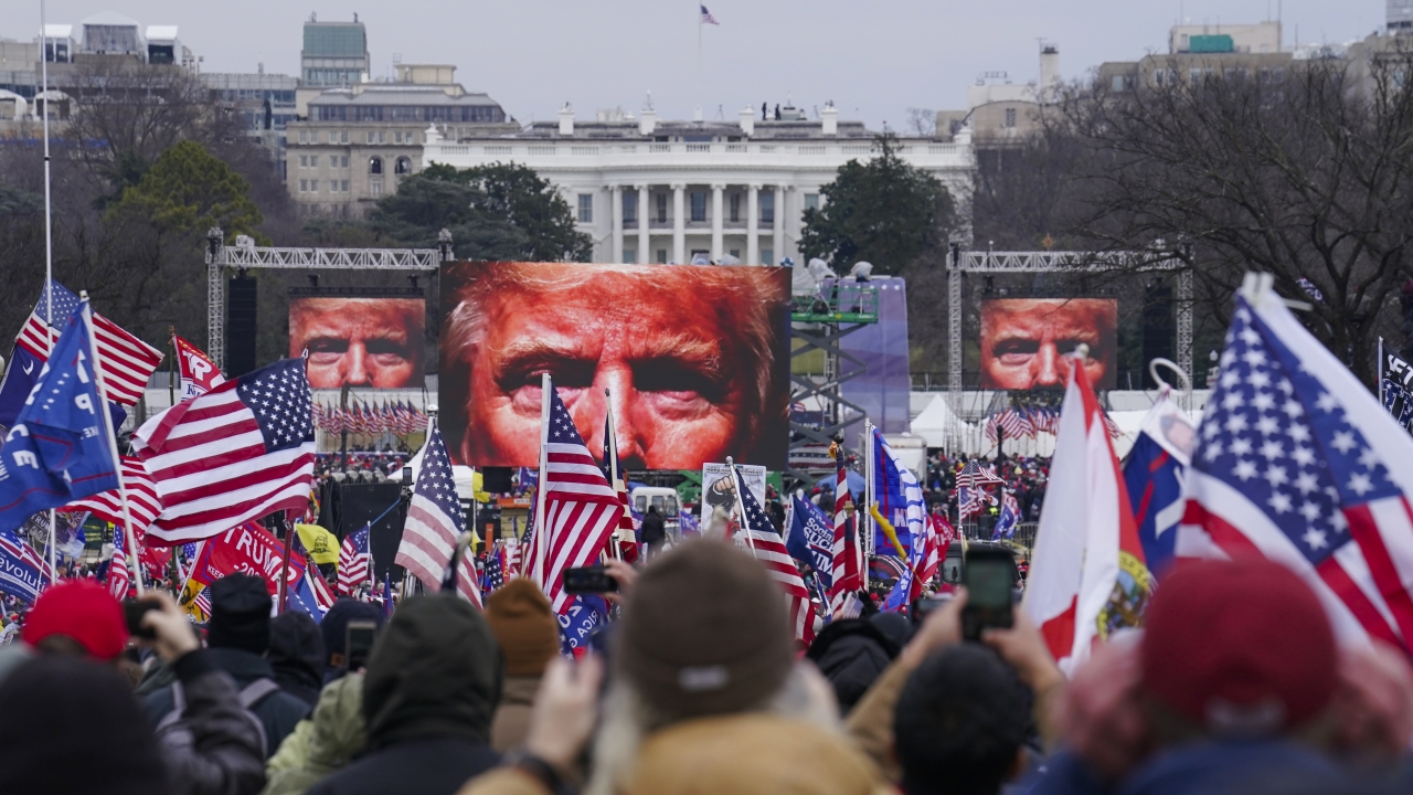 In this Jan 6. 2021, file photo, the face of President Donald Trump appears on large screens.