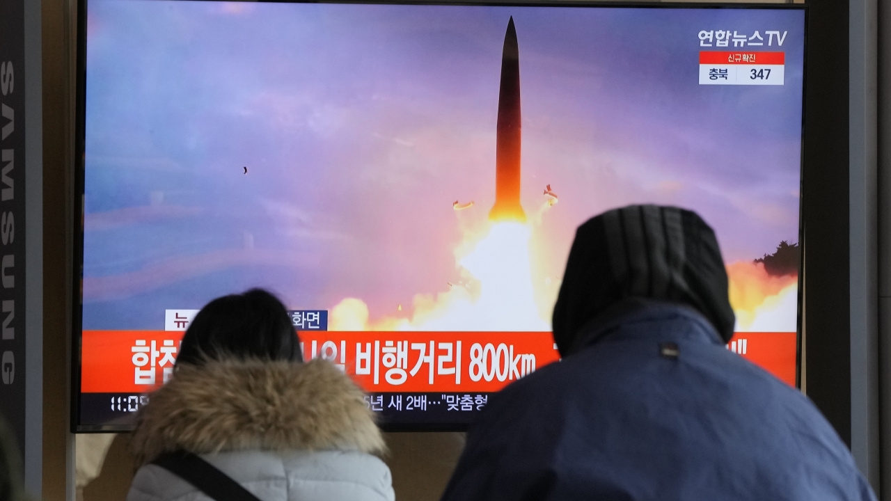 People watch a TV showing a file image of North Korea's missile launch during a news program