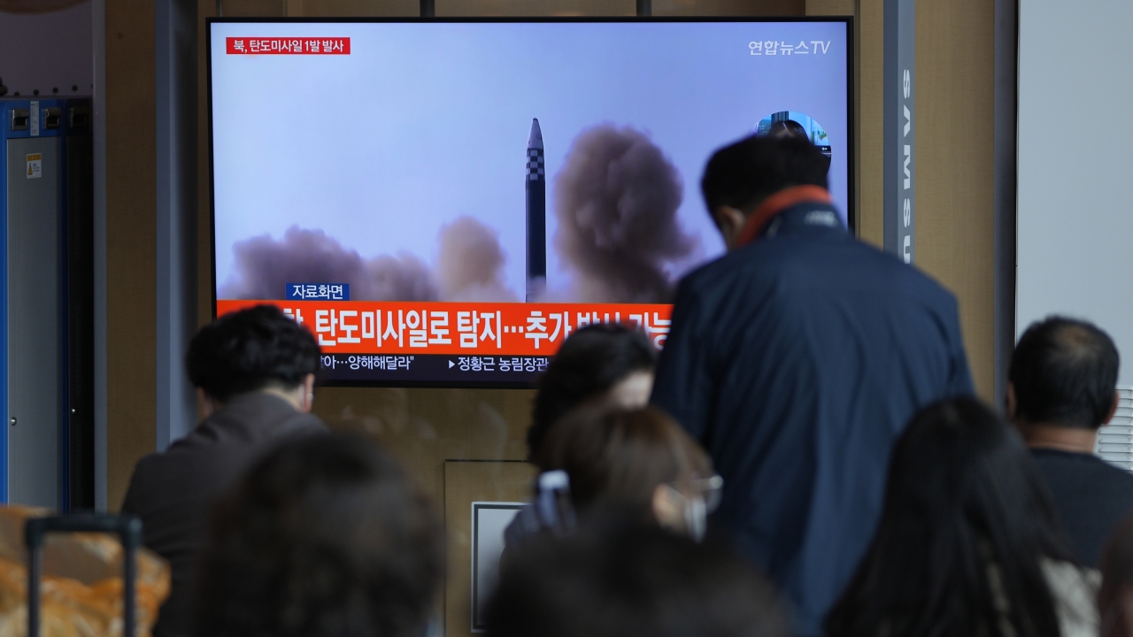 People watch a North Korean missile launch on TV