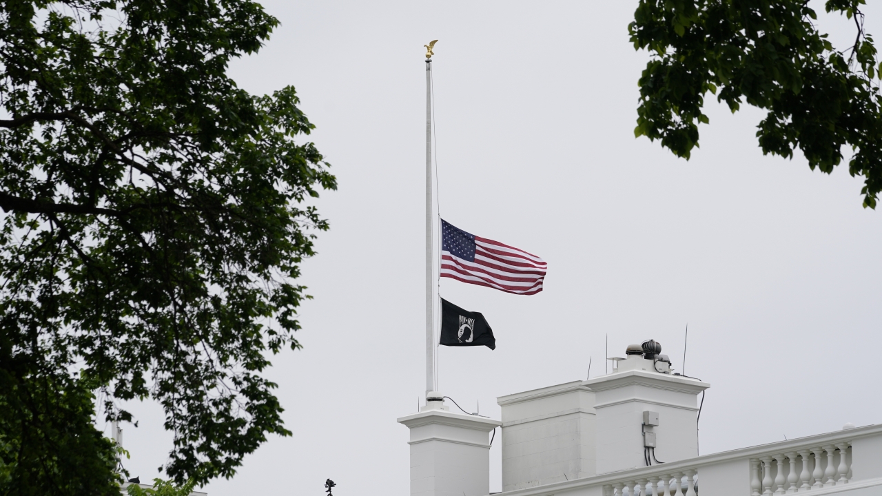 The American flag flies at half-staff at the White House to commemorate 1 million American lives lost due to COVID-19