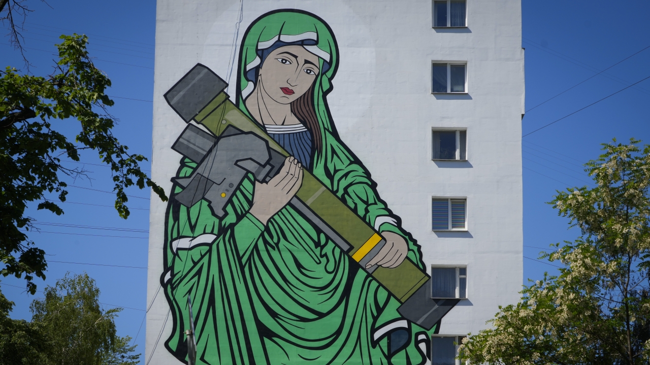 A mural depicts an image known as "Saint Javelina," Virgin Mary cradling an anti-tank weapon, on a building wall in Ukraine