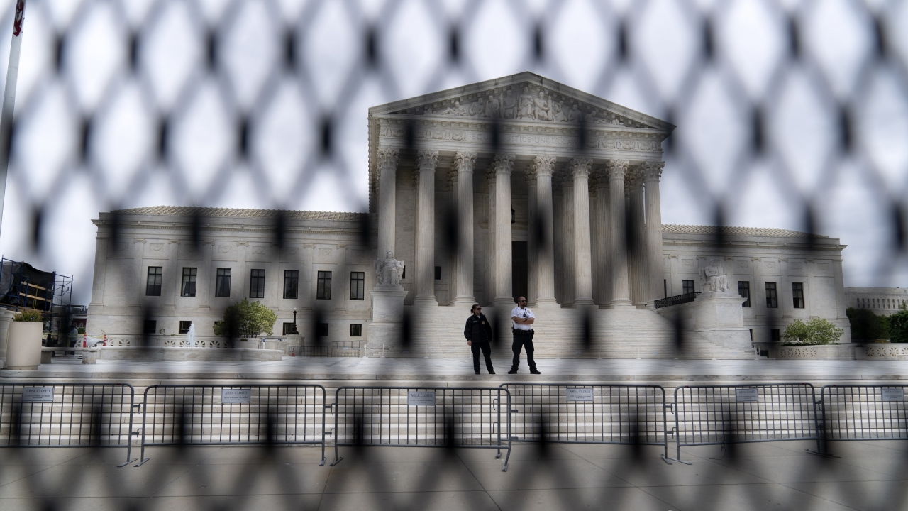 The U.S. Supreme Court is seen behind a fence who stands around the building