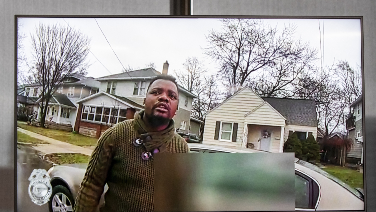 A TV display shows video evidence of a Grand Rapids police officer struggling with and shooting Patrick Lyoya