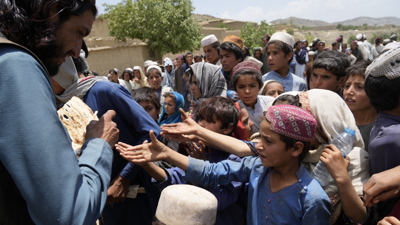 Afghan children line up for bread at a camp after an earthquake