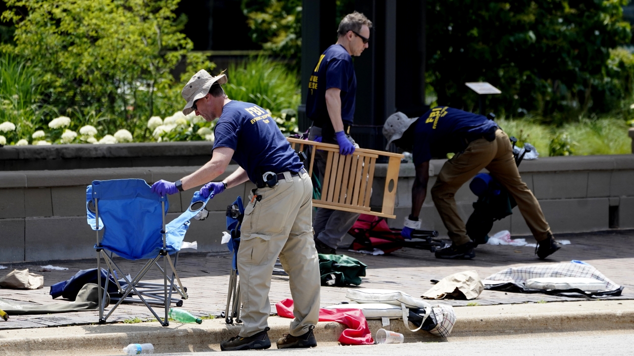 Members of the FBI's evidence response team remove personal belongings one day after a mass shooting in Highland Park, Ill.