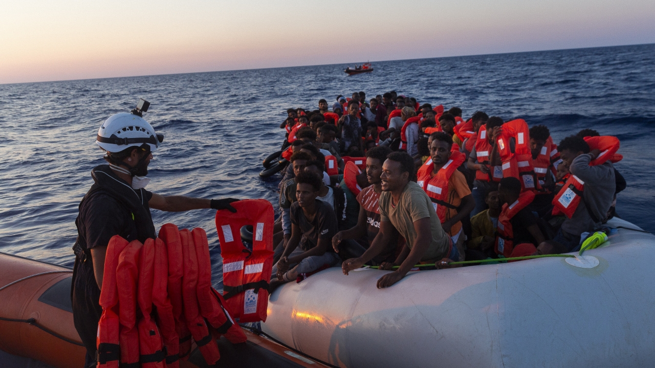 Crew of the Sea-Watch 3 distribute life jackets to 108 people in a boat in distress in the central Mediterranean