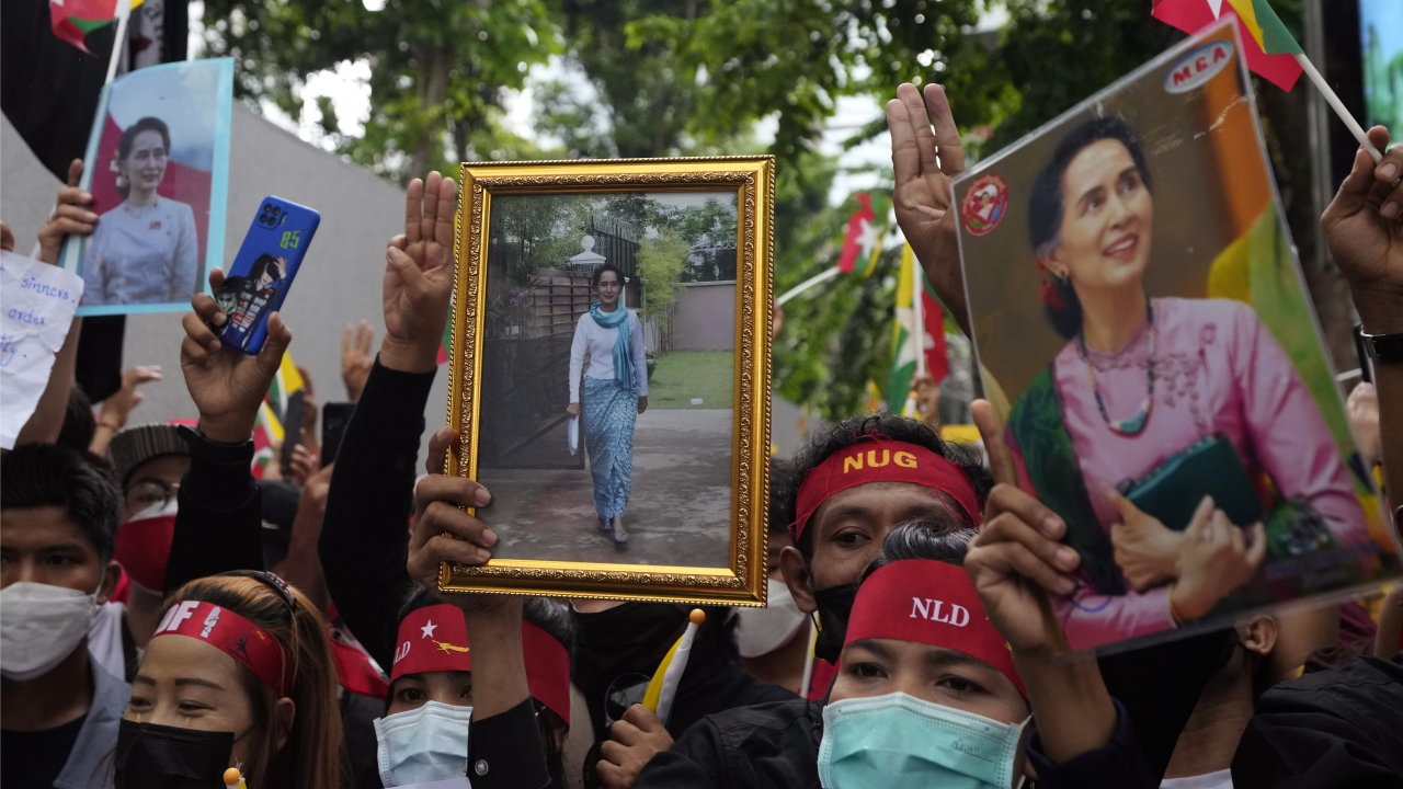 Myanmar nationals living in Thailand hold the pictures of deposed Myanmar leader Aung San Suu Kyi as they protest