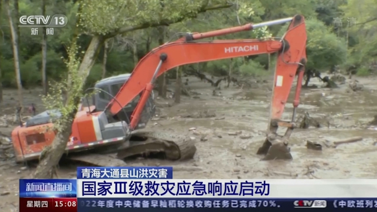 An excavator tries to clear mud from an area in the aftermath of flooding in Datong county in western China