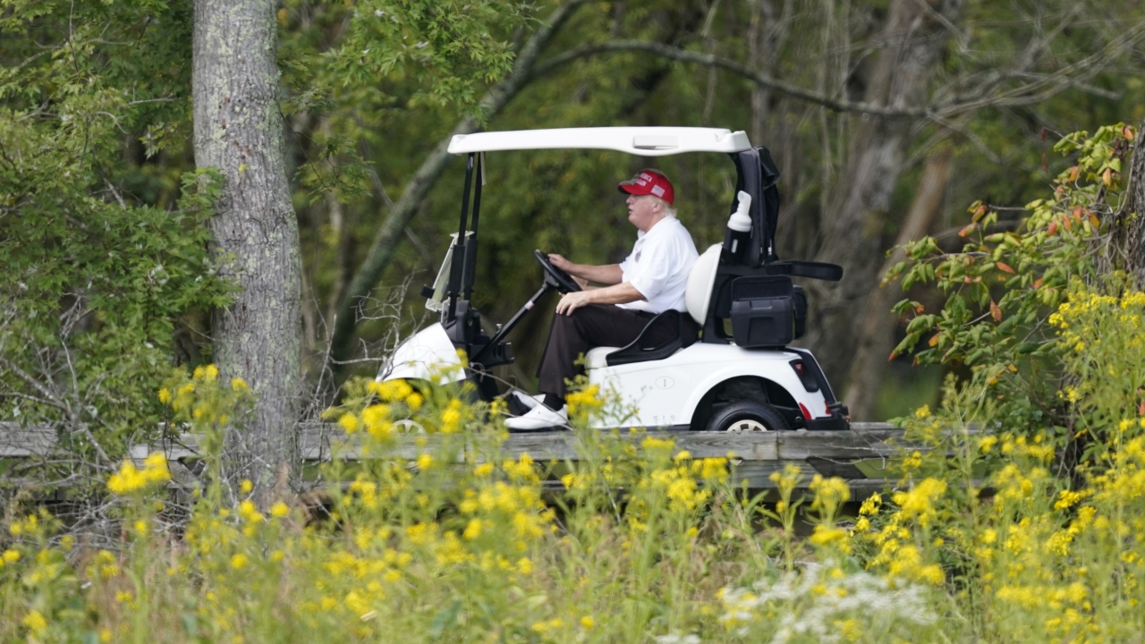 Former President Donald Trump rides around his golf course.