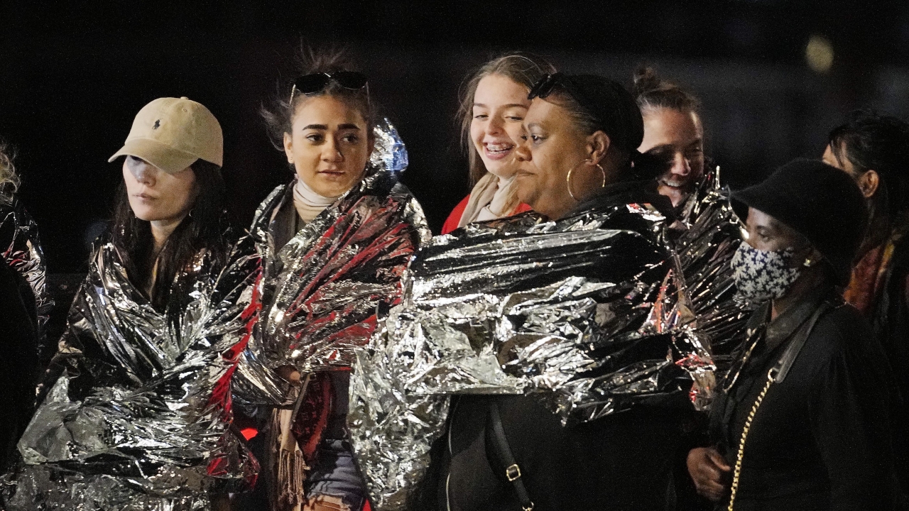 People in warming foil wait to see the late Queen Elizabeth II.