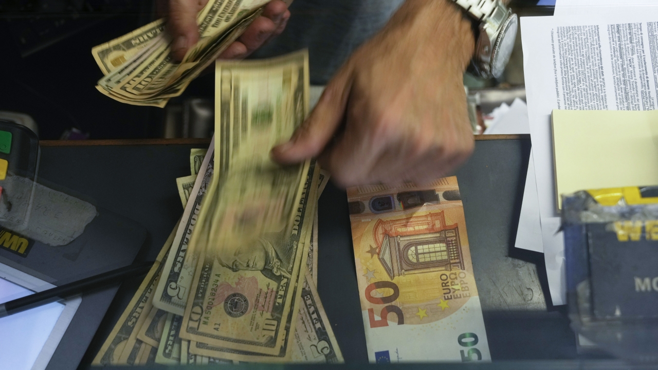 Cashier exchanges Euros with U.S. dollars.