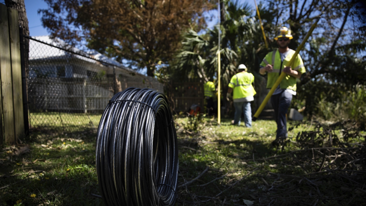 Workers for Florida Power and Electric repair a power line damaged by Hurricane Ian.